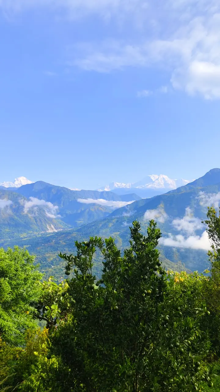 Snow peaks of the Himalaya above green hills in Kaligandaki Rural Municipality